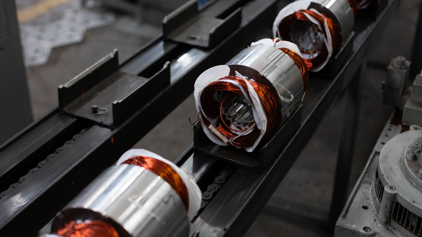 A row of x team metal rollers with red and white paint, used for industrial purposes.