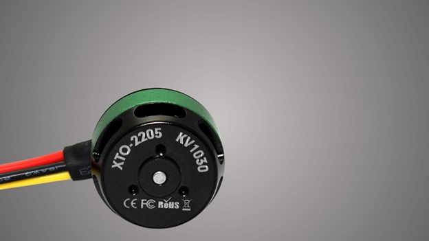 A close-up view of a small black and green wire servo motors, showcasing its intricate details and color contrast