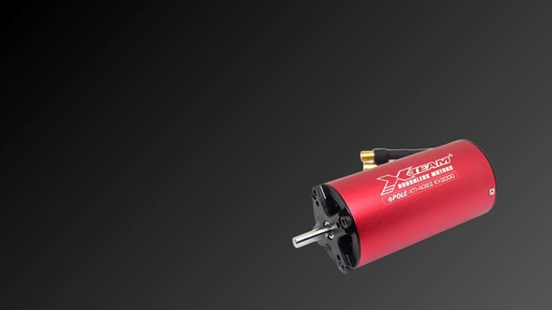 A vibrant red X team motor prominently displayed against a sleek black background, highlighting its design and color contrast.