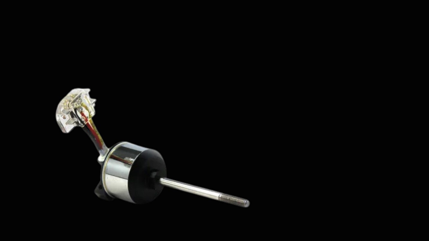 X team small motor connected to a wire, showcasing its compact design and functionality in a mechanical context.